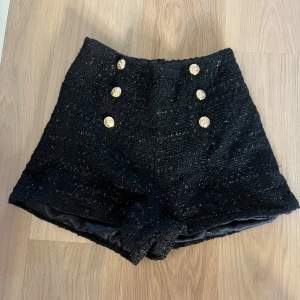 Snygg högmidjade shorts med guld detaljer. Dragkedja i sidan. Storlek S. 