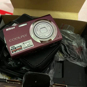 Nikon Coolpix s230 - Nikon Coolpix s230 i färgen plum. Perfekta kameran för Y2K bilder 🎀✨ Kommer med sladd, laddare, batteri och SD kort ☀️ Pris kan diskuteras 🎀