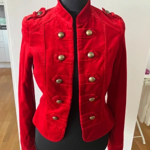 Cool röd sammetsjacka med kinakrage och knappar, storlek 36 - Denna coola röda sammetsjacka är i gott  skick. Har foder. Jackan är öppen, det vill säga går inte att knäppa. Storlek 36. Från Hm. 