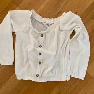 Singoallablus - Fin långärmad singoallablus med knappar.  Vit/creamvit. Från hm.