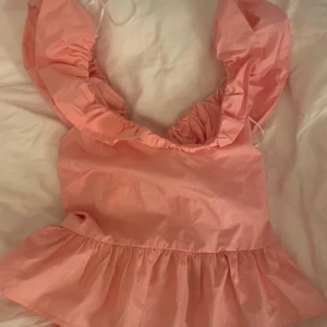 Rosa topp med volanger - Säljer en superfin rosa topp som jag aldrig har använt!! (Lånade bilder)