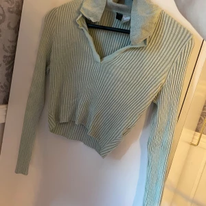 Ljusgrön ribbad tröja - Säljer en ljusgrön ribbad tröja med krage och v-ringning. Tröjan är croppad och har långa ärmar. Perfekt för höst och vår! 🧡