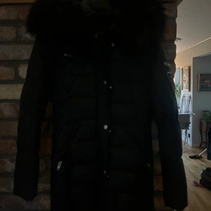Svart dunjacka från Rockandblue - Säljer en svart dunjacka från Rockandblue med pälskantad huva som tyvärr blivit för liten. Jackan är använd några fåtal gånger under en vinter så är i väldigt fint skick. Storlek 36. Köpt för 3500, säljer för 1500:)