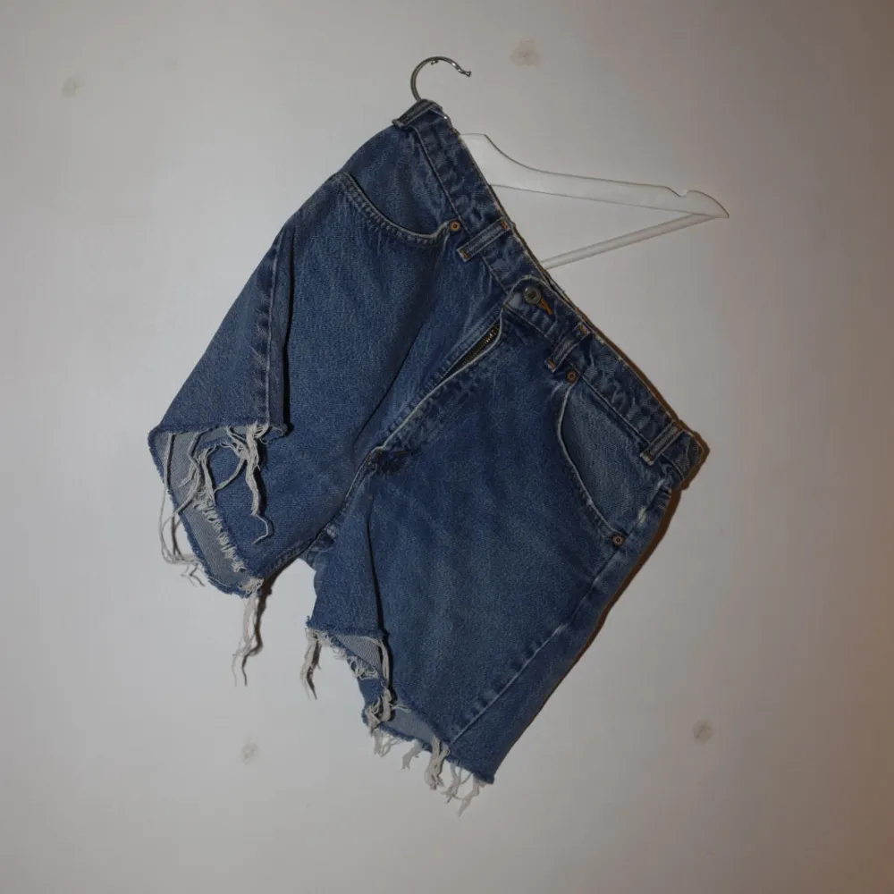 Säljer ett par snygga blå jeansshorts från Levi's i bra skick. Har svårt att säga exakt storlek. Står 34 i gammal jeansstorlek men kan gissa att de är ungefär 40-42 . Shorts.