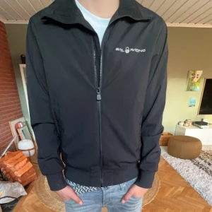 Svart jacka från Sail Racing - Säljer en svart jacka från Sail Racing i mycket bra skick. Den har en dragkedja framtill och är långärmad. Perfekt för höst och vinter med sin stilrena design. Passar både till vardags och lite mer uppklädda tillfällen. Den är i storlek S och ny pris ligger runt 2000.