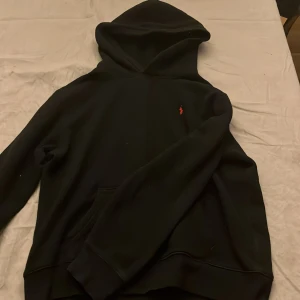 Svart hoodie från Polo Ralph Lauren - Säljer en klassisk svart hoodie från Polo Ralph Lauren i storlek XL. Den har en liten röd logga på bröstet och är perfekt för både höst och vinter.  