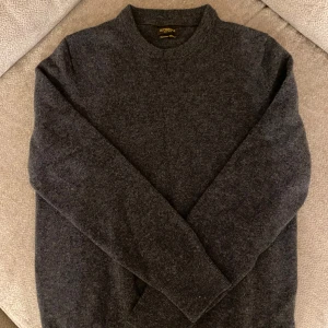 Mörkgrå kashmirtröja från Gutteridge - Säljer en supermjuk och stilren mörkgrå tröja från Gutteridge i kashmirblandning. Köpt i Milano, använt enbart ett fåtal gånger. 