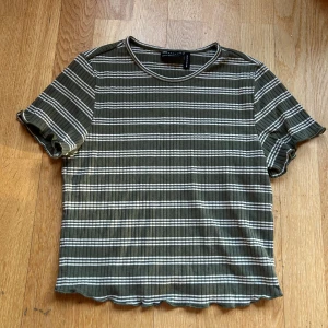 Randig ribbad topp från ASOS Design - Säljer en superfin randig topp från ASOS Design i grönt och vitt. Den är ribbad och har en croppad passform med korta ärmar. Perfekt för sommardagar eller en avslappnad stil. Toppen är i mycket bra skick och redo för en ny garderob! 💚