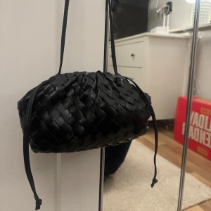 Flätad väska  - Svart flätad väska, aldrig använd. Bra skick samt att bandet är justerbart