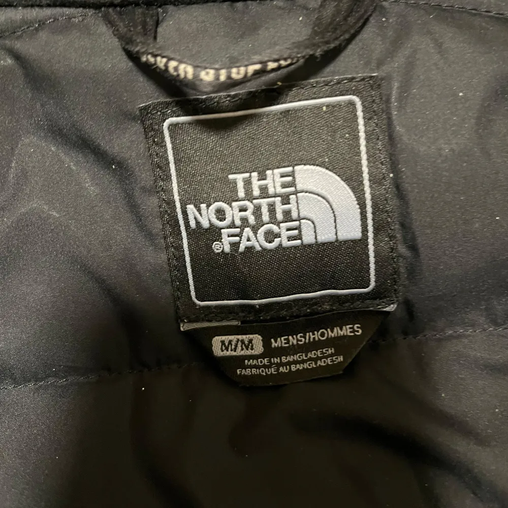 Säljer en svart jacka från The North Face med huva och flera praktiska fickor. Jackan har en dragkedja framtill och är perfekt för kyligare väder. Den är långärmad och har en stilren design med logotyp på bröstet och ryggen.. Takit.