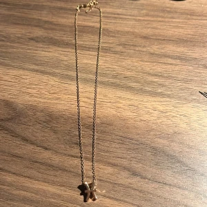 Guldhalsband med hängsmycke - Elegant guldhalsband med ett unikt hängsmycke i form av två figurer. Perfekt för att ge en personlig touch till din stil. Kedjan är tunn och smidig, vilket gör den bekväm att bära hela dagen.