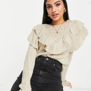 Beige stickad tröja med volangdetaljer - Snygg beige stickad tröja med volangdetaljer på axlarna. Tröjan har ett fint stickat mönster och långa ärmar, perfekt för kyligare dagar. Passar bra till både jeans och kjol. Köpt för 339kr på asos! Tröjan har blivit använd cirka 2 gånger och är därför i mycket fint skick! 