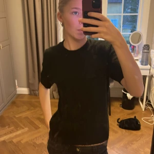 Svart stickad  t-shirt - En klassisk svart t-shirt stickad med normal passform och korta ärmar. Perfekt för en enkel och stilren look. Från HM perfekt  passform 