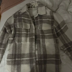 Rutig overshirt i grå och vit - Rutig kappa/jacka från HM.  Passar M och S