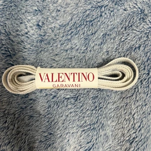 Skosnören från Valentino Garavani - Två par skosnören från Valentino Garavani. Båda  par är helvita och marin blå. Perfekta för att ge dina skor en lyxig touch.