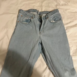 Ljusblå jeans från Weekday - Säljer ett par ljusblå jeans med klassisk femficksdesign och knappgylf. Perfekta för en avslappnad stil. De har en rak passform och är tillverkade i slitstarkt denim.