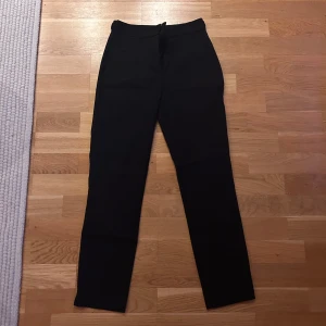 Svarta kostym byxor från Zara i storlek S - Snygga svarta byxor från Zara med medelhög midja och dragkedja. Byxorna har en rak passform och är tillverkade i ett bekvämt material. Aldrig använda. 