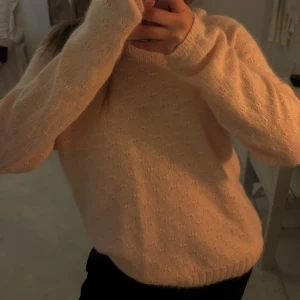 Rosa stickad tröja - Mysig rosa stickad tröja med diskret mönster. Tröjan har långa ärmar och ribbstickade muddar vid ärmslut och nederkant. Perfekt för kyliga dagar!
