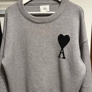 Grå tröja från Ami Paris - Ami Paris tröja, grå med svart hjärta. Den är i nyskick