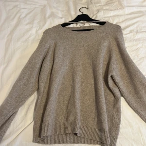 Beige stickad tröja - Mysig beige stickad tröja med rund hals och långa ärmar. Perfekt för kyliga dagar med ribbstickade muddar vid ärmslut och nederkant.