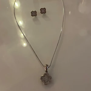 Van Cleef smyckesset  - Elegant set med halsband och örhängen. Jag fick den i julklapp men jag säljer den för jag bara använder guld. Perfekt för att ge en touch av glamour till din stil. Stämpeln på halsbandet (se bild), jag tror det står för sterling silver. 