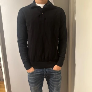 Svart pikétröja - Tja, säljer nu denna as snygga och stilrena pikétröja. Tröjan har inga defekter eller liknande och är sparsamt andvänd. Hör av er vid eventuella frågor! 