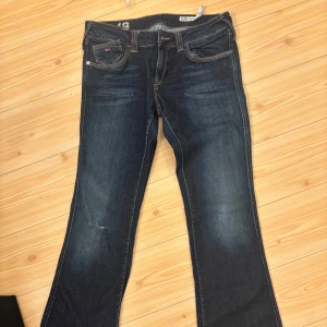 Mörkblå jeans från Tommy Hilfiger - Snygga mörkblå jeans från Tommy Hilfiger! De är i bra skick och har ett hål på knät (det är en sån design på jeansen) 