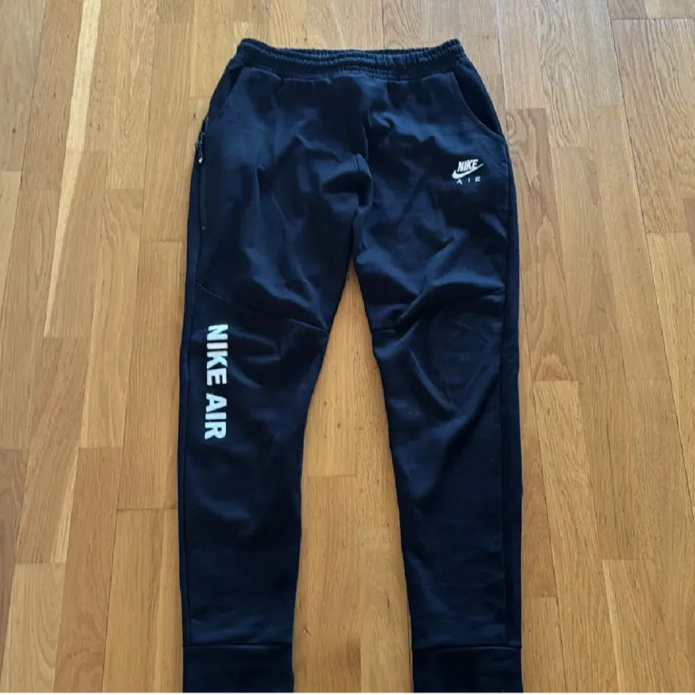 Säljer ett par svarta mjukisbyxor från Nike. Priset kan diskuteras vid snabb affär. vit Nike Air-logga på benet. Byxorna har elastisk midja och dragkedja vid fickorna. Perfekta för en avslappnad stil.. Farkut & Housut.