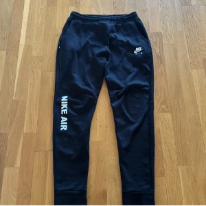 Svarta mjukisbyxor från Nike - Säljer ett par svarta mjukisbyxor från Nike. Priset kan diskuteras vid snabb affär. vit Nike Air-logga på benet. Byxorna har elastisk midja och dragkedja vid fickorna. Perfekta för en avslappnad stil.