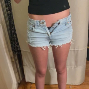 Ljusblå jeansshorts med fransar - Säljer ett par ljusblå jeansshorts med fransiga kanter. Shortsen har en låg midja. Jag har 75cm runt min midja och shortsen ör för små för mig, därför säljer jag dem💕💕