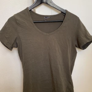 Grön/Grå tshirt - Grön/Grå tshirt köpt secondhand, står ej storlek men skulle säga xs/s