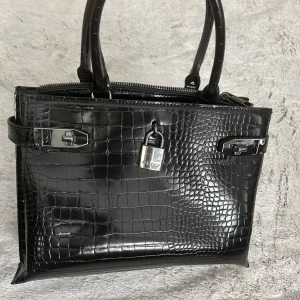 Väska - Svart väska från Aldo🖤 Helt ny, oanvänd. Har flera fack och kommer även med en axelrem.  Den är ca 28 cm