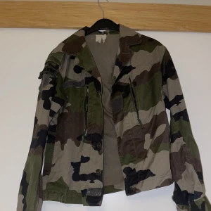 Camo jacka second hand - Bra skick, köpt second hand  Några trådar som hänger men bara att klippa av Ingen storlek men passar en S, lite kortare modell/slutar vid rumpan