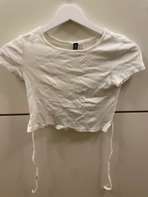 Sommartröja - Fin croppad tshirt från hm med knyte på ryggen. Jättebra skick då jag bara använt fåtal gånger!