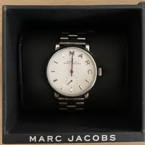 Silver klocka från Marc Jacobs i orginal förpackning. Sparsamt använd. Otroligt fint skick. Alla extra delar på klockbandet medförljer.