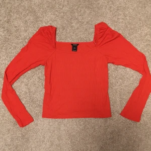 Röd långärmad topp - En supersnygg röd långärmad topp med lite puffiga ärmar. Är ribbad, i storlek S från lindex och helt ny. 