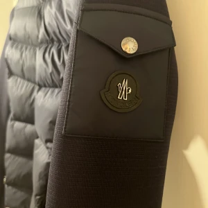 Mörkblå moncler cardigan jacka - Säljer denna marinblå cardigan från moncler med stickade armar och vaddering runt kroppen. Storlek xs/s och helt i nyskick, inga tecken alls på användning. Pris kan diskuteras vid snabb affär