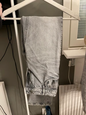 Gråa jeans med slits - Gråa jeans med slits från zara!! Helt oanvända. Storlek 32, nypris 299. (Midwaist)