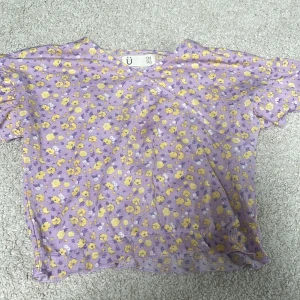 Blus - En jättefin sommarblus från Kappahl. Lila tyg med gula och vita blommor