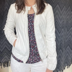 Vit skinnjacka i skinimitation  - Fin jacka i skinimitation. Nyskick endast använd 2 gånger