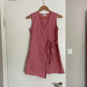 Gingham klänning  - Säljer denna supersöta rutiga omlott-klänning från Weekday! Köpt av en annan tjej här på Plick men var tyvärr för kort för mig 🥲