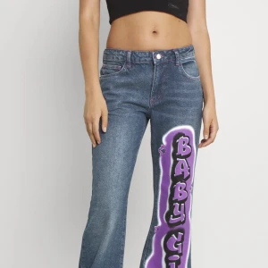 Low-Rise jeans med tryck - Säljer dessa coola Low-Rise ”babygirl” tryck med bootcut i storlek M! (W28) Köpta på JADED LONDON  Säljer då de är i fel storlek. Endast prövade, jag är 170, de sitter som S/M och är i bra längd!