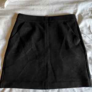 Kjol - Svart kjol i mocka. Köpt på Vero Moda i storlek S!