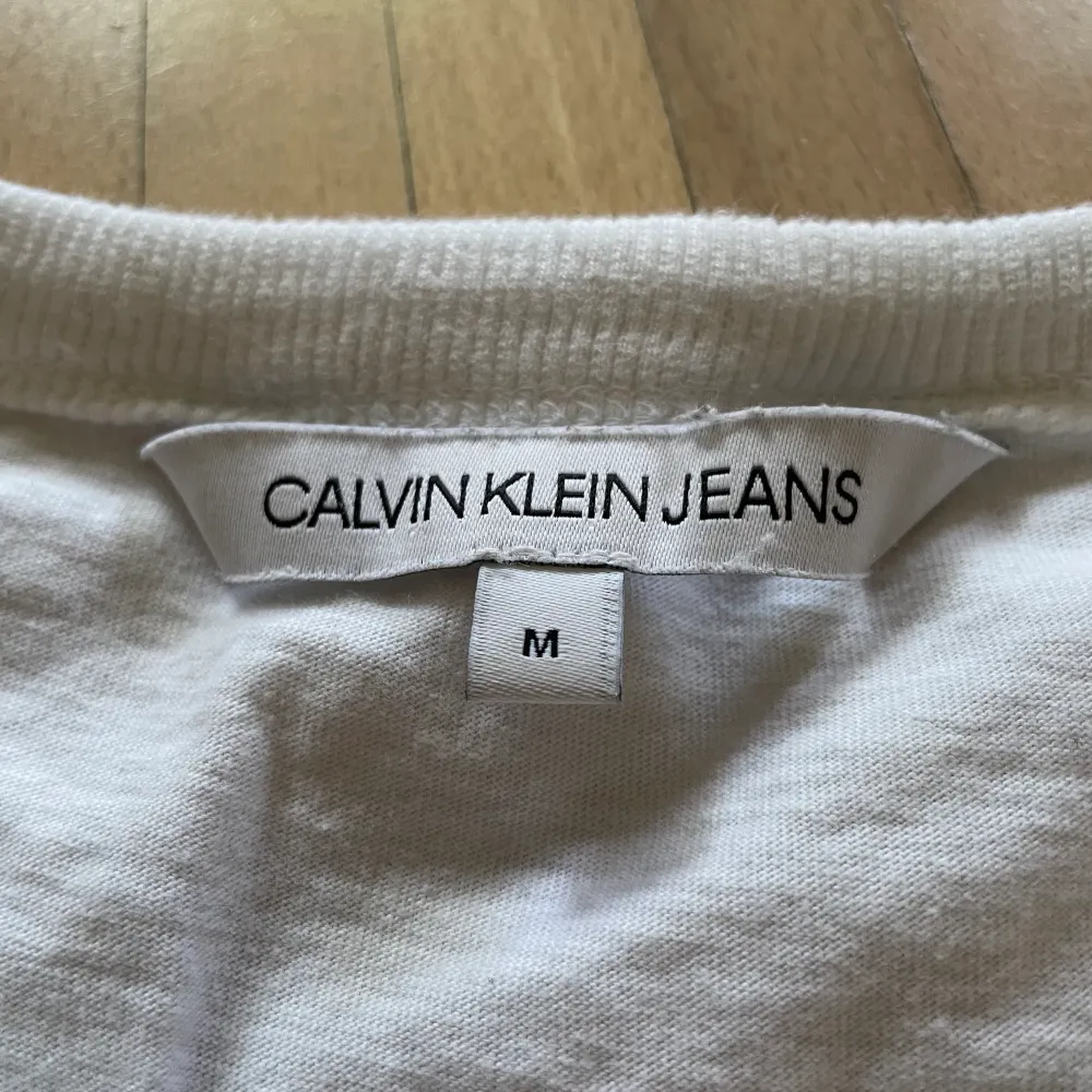 Calvin Klein Jeans T-shirt med en loggad patch på vänster arm.  Köpt för 450kr på Calvin Klein Köparen står även för frakten!. T-shirts.