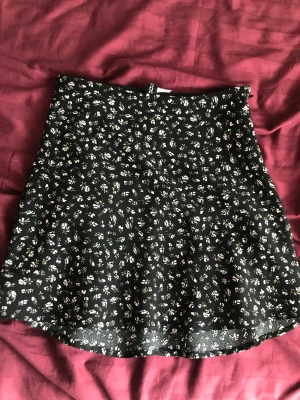 Kjol blommmönster - En kort kjol med blommmönster från HM som tyvärr är förliten.