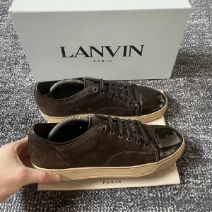 Lanvin skor - Säljer mina lanvin skor i storlek  EU 43 uk 9, skorna är i bra skick förutom defekten på bild 2. Svart lanvin dustbag tillkommer, pris 2000kr (nypris 4500kr). Hör gärna av dig om du har frågor.