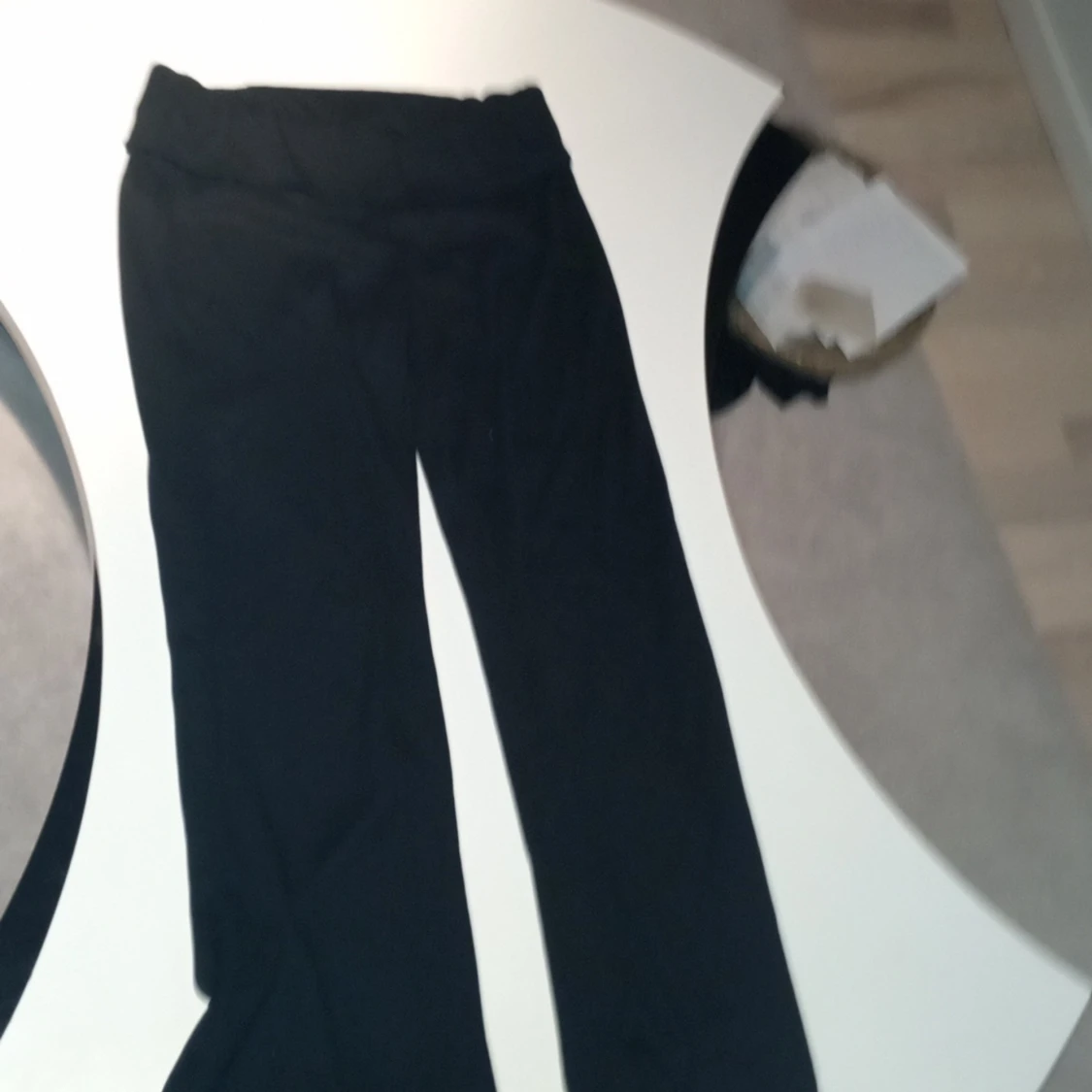 Svarta utsvängda byxor som är vikna - 90