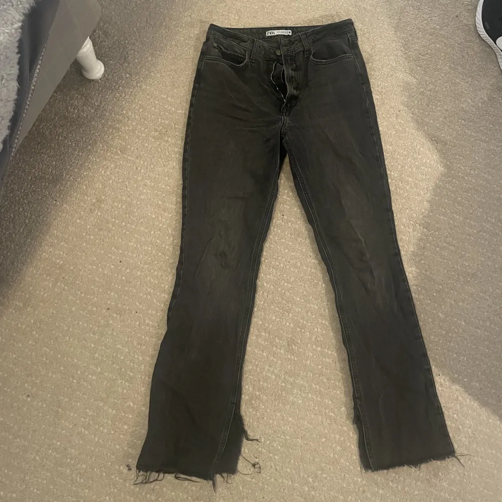 Fina mörkgråa jeans ifrån Zara med slitningar + slits längst ner. Dom är i fint skick.. Jeans & Byxor.