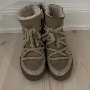 Supersnygga beiga inuikki skor!! - De här skorna är i storlek 34 och har varit mycket omtyckta! De är i använt skick och gummit är lite lite slitet fram på skorna, men det är inte jätte synligt. Säljer dem därför billigt.