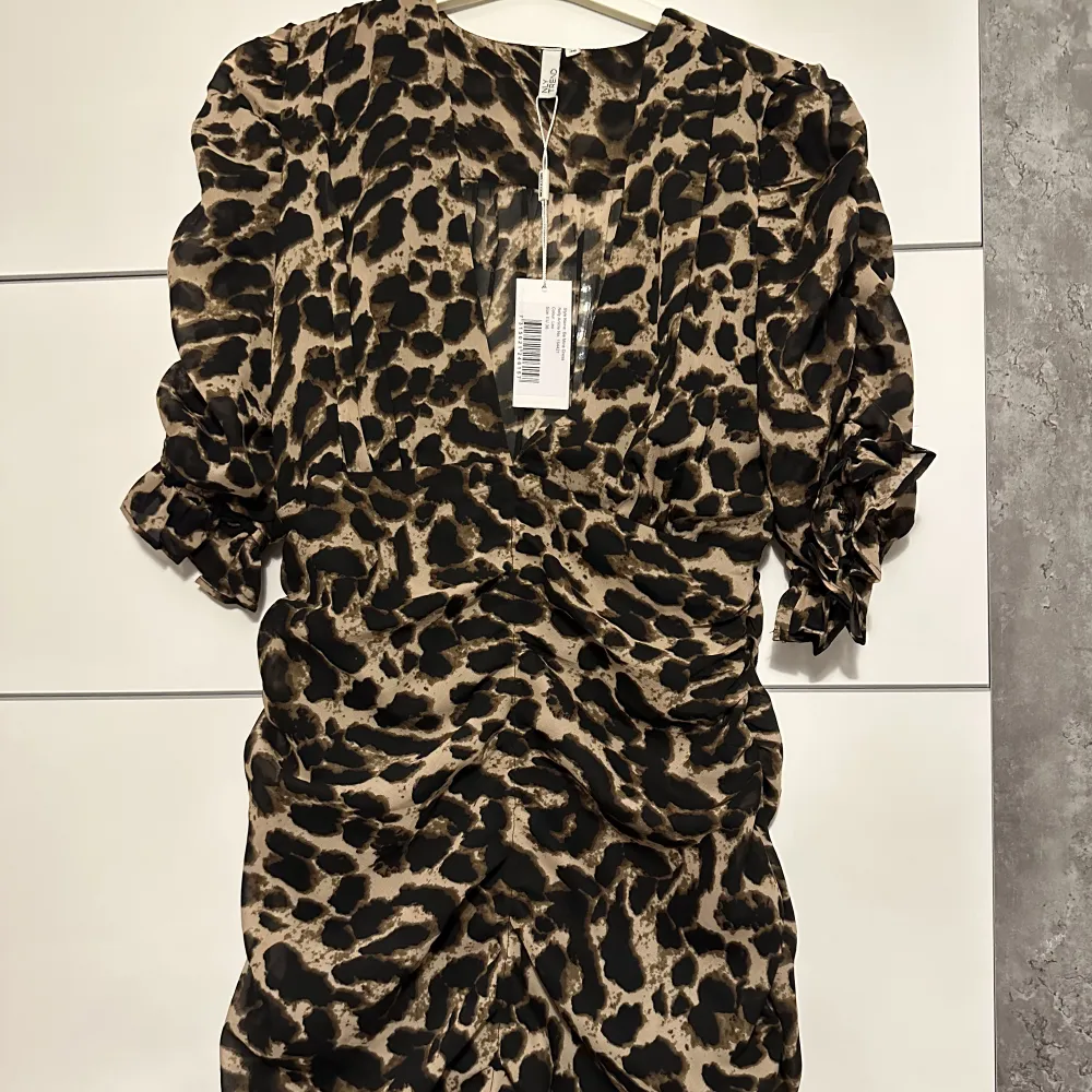 Säljer en fin leopard klänning som jag inte har tagit på mig. Den är helt ny och prislappen står fortfarande på. Är i storlek 36 och är medel lång.. Klänningar.